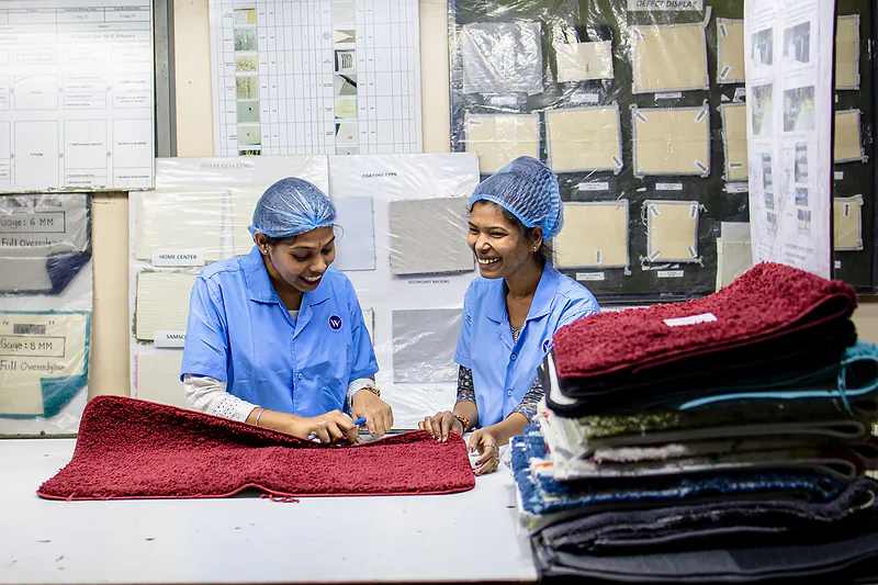 Dos inspectoras revisan piezas textiles antes del envío.