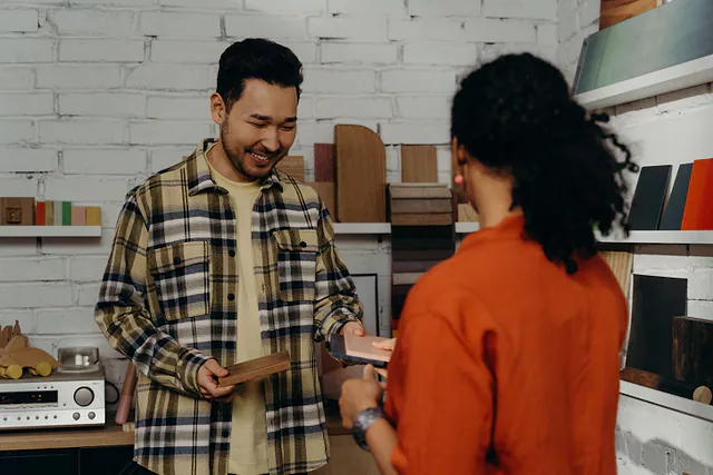 Un proveedor entrega una muestra de material a la compradora en su showroom.